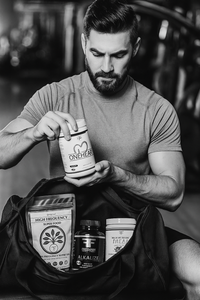 Thumbnail for Fit, bearded man packing Freeman Formula heart health supplement stack (One Heart, Alkalize, Synergize, Superfood, Complete Meal) into gym duffle bag at fitness center. Black and white lifestyle photo with red and gold product accents.